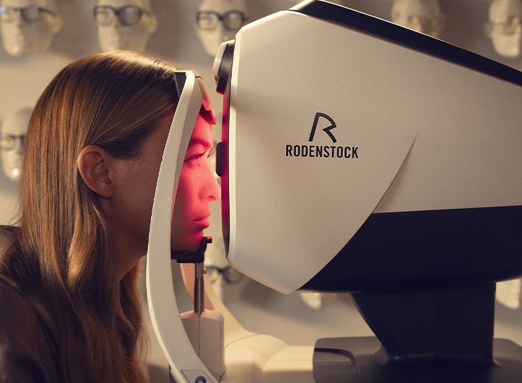 Vrouw zit voor de DNEye-scanner tijdens een oogmeting
